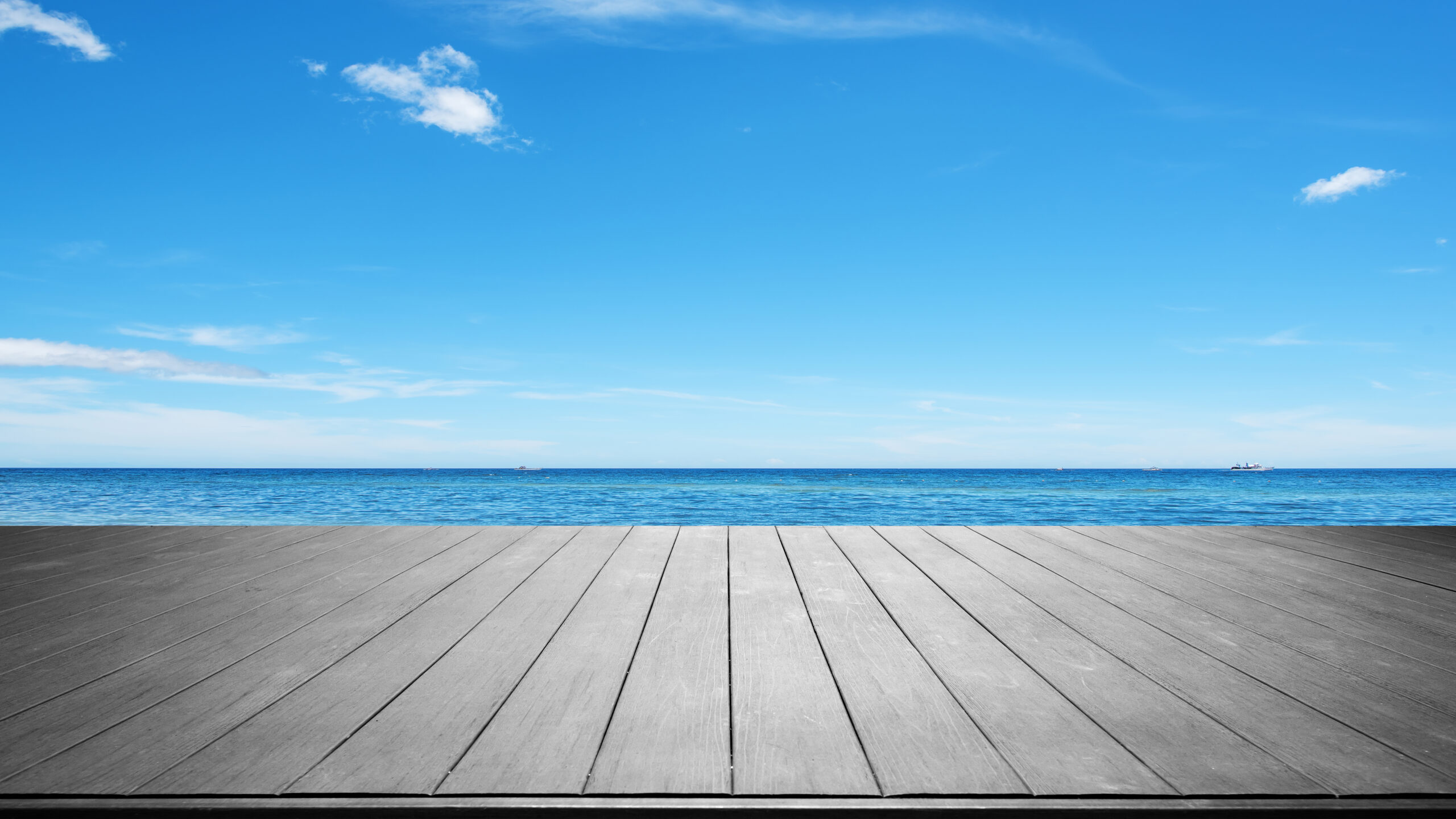 Wooden terrace with tropical ocean and blue sky background
